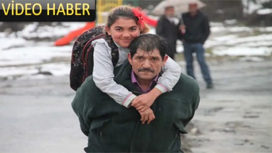 KÖYLÜLER ÇOCUKLARINI SEL SUYUNDAN KARŞI YOLA SIRTLARINDA GEÇİRİYOR